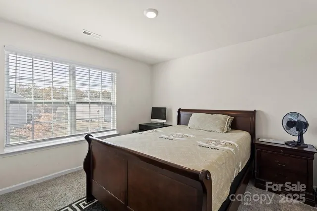 a bedroom with a bed and a large window