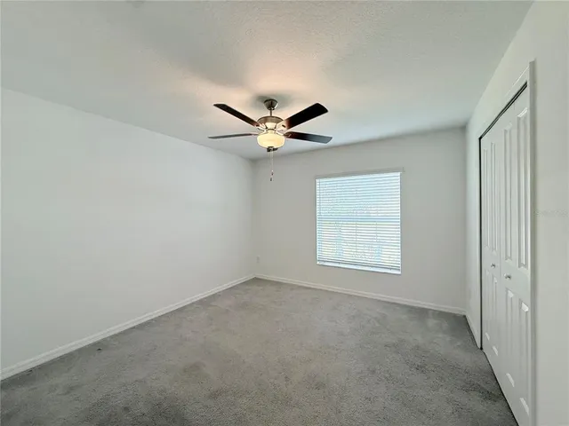 a view of a livingroom with a ceiling fan and window