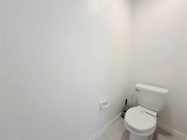 a white toilet sitting next to a white wall
