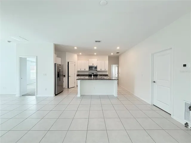 a view of kitchen with refrigerator and window
