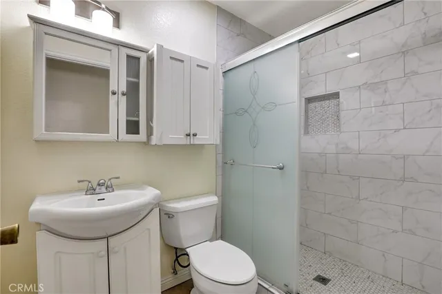 a bathroom with a sink a toilet and shower