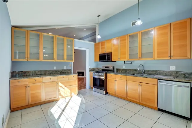 a kitchen with stainless steel appliances granite countertop a stove sink and cabinets