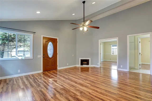 a view of empty room with wooden floor and fan