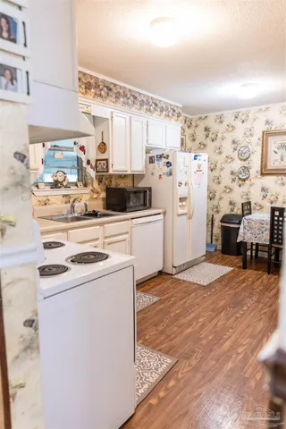 a kitchen with stainless steel appliances a stove a refrigerator and white cabinets