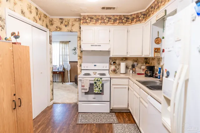 a kitchen with a refrigerator and white cabinets