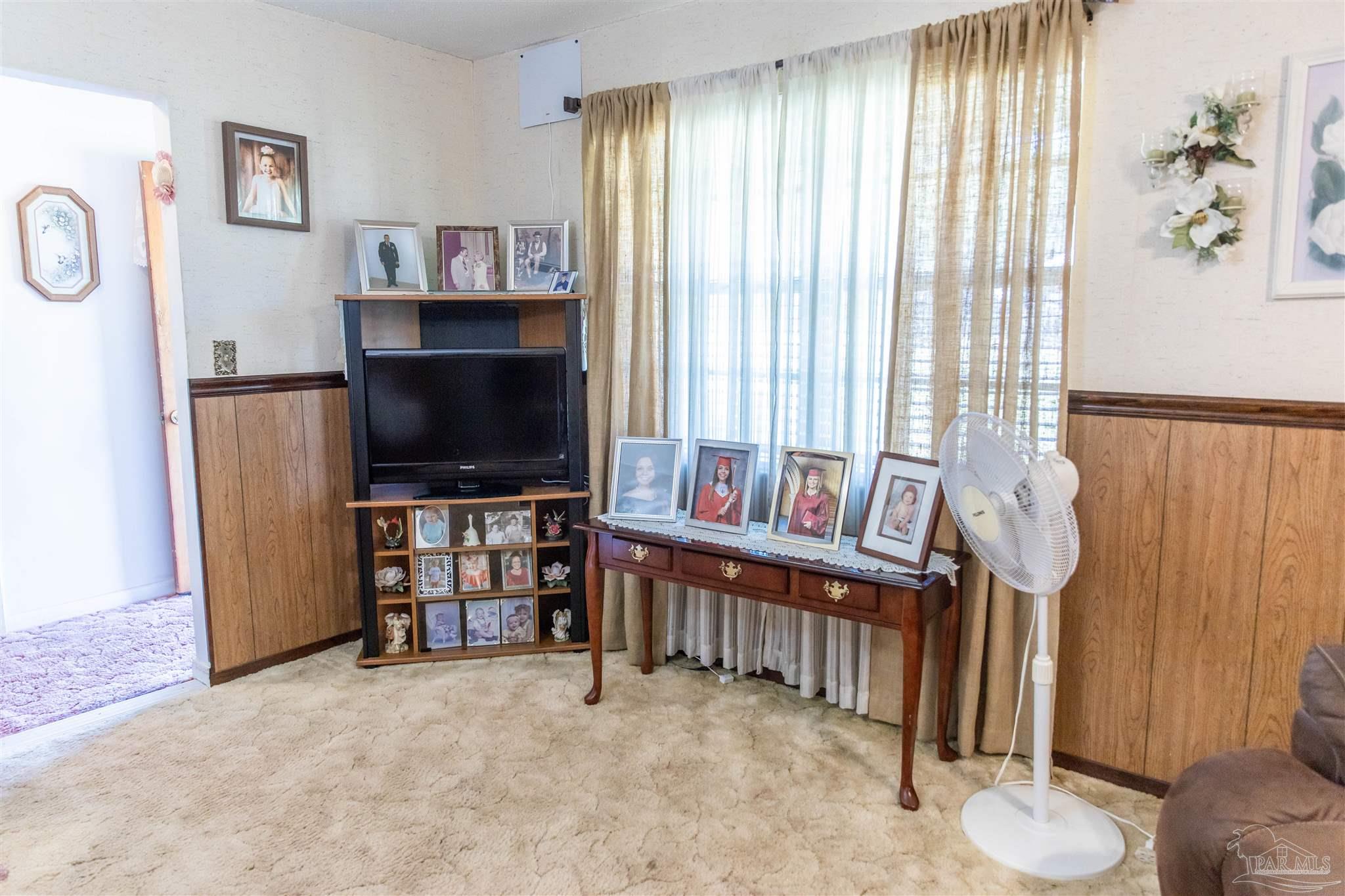 7569 Pine Meadows Loop Milton, FL 32571 - Photo 15 of 25 a living room with furniture and a flat screen tv