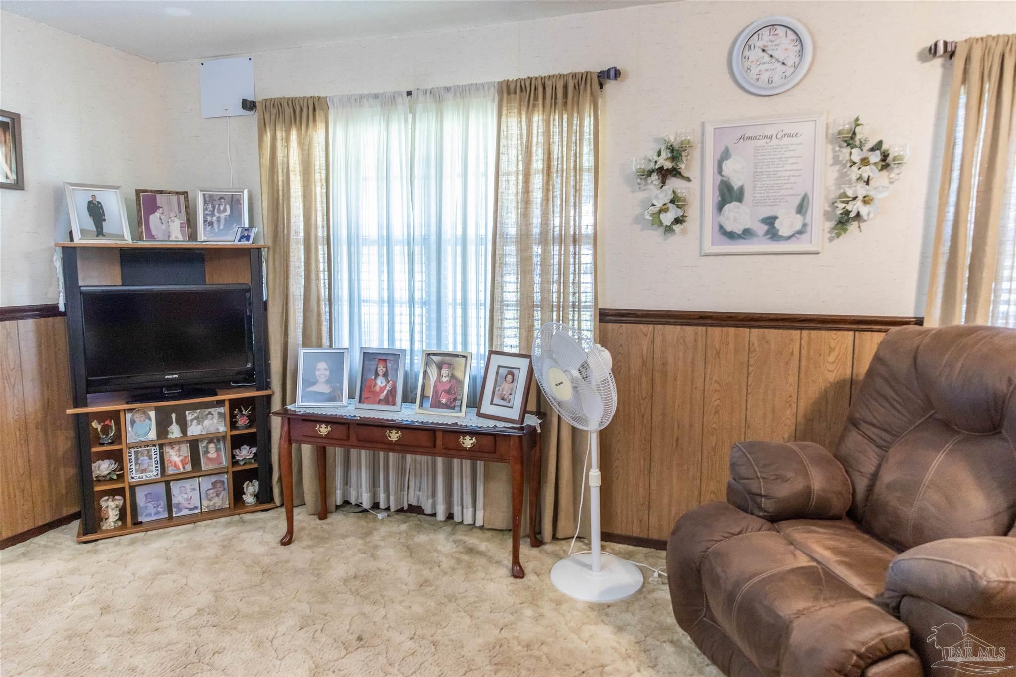 7569 Pine Meadows Loop Milton, FL 32571 - Photo 16 of 25 a living room with furniture and a flat screen tv