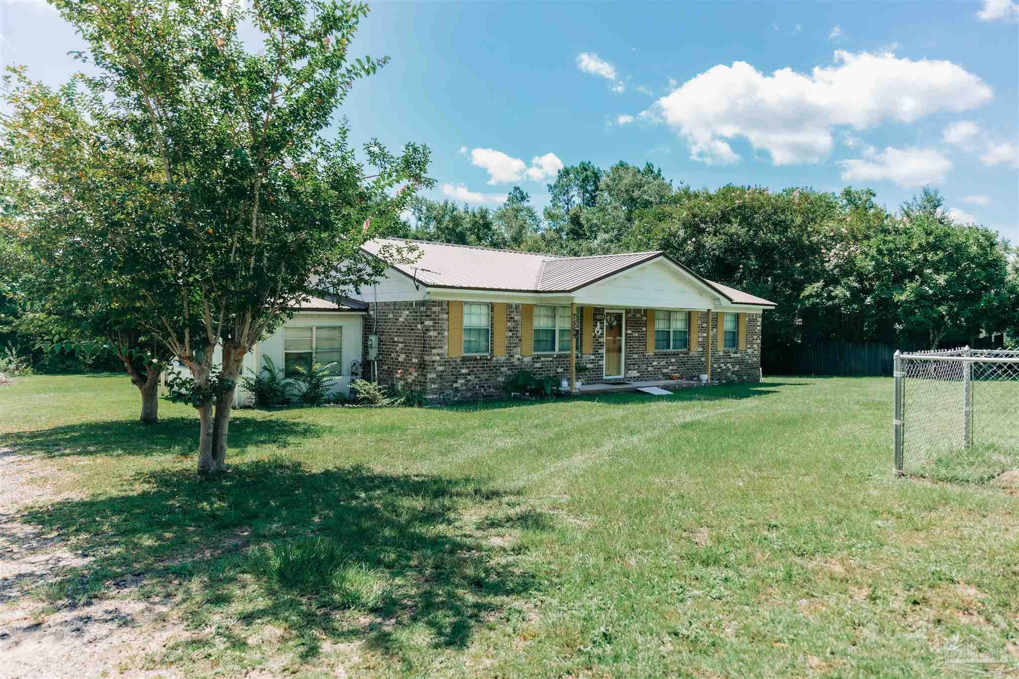7569 Pine Meadows Loop Milton, FL 32571 - Photo 2 of 25 a front view of a house with garden