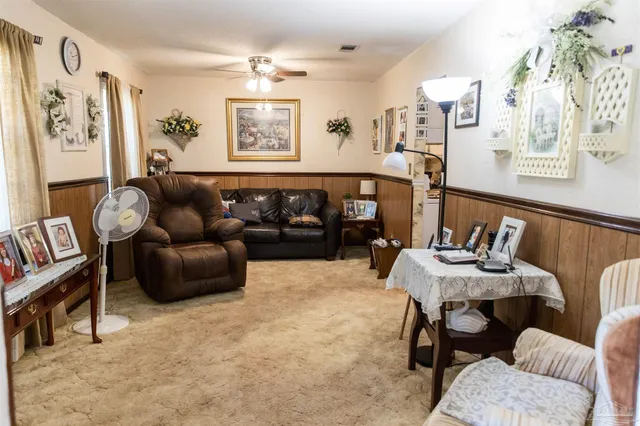 a living room with furniture and paintings on the wall