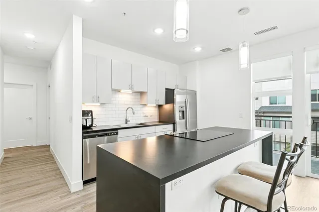 a kitchen with stainless steel appliances granite countertop a sink refrigerator and cabinets