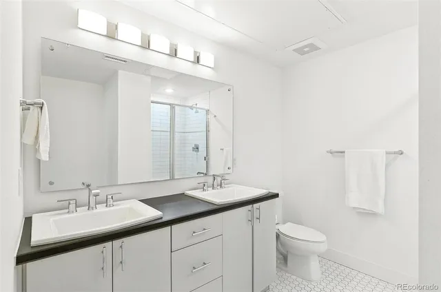 a bathroom with a toilet a sink a mirror and vanity