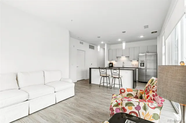 a living room with furniture and kitchen view