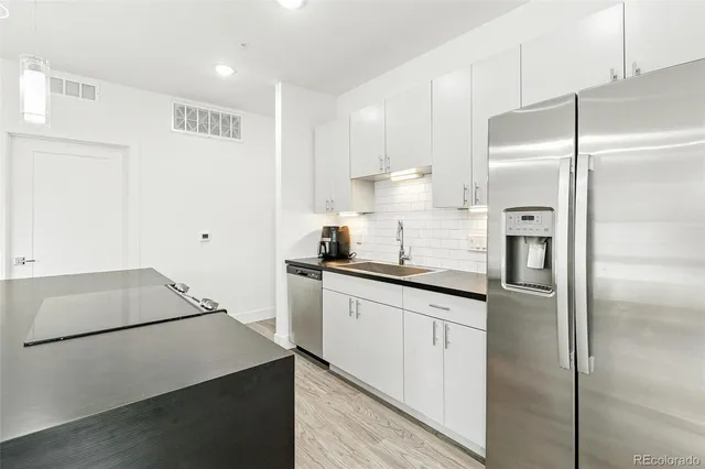 a kitchen with a refrigerator sink and cabinets