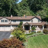 a front view of a house with a yard and trees