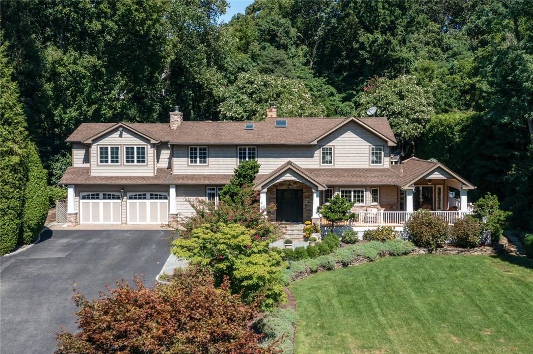 a front view of a house with a yard and trees