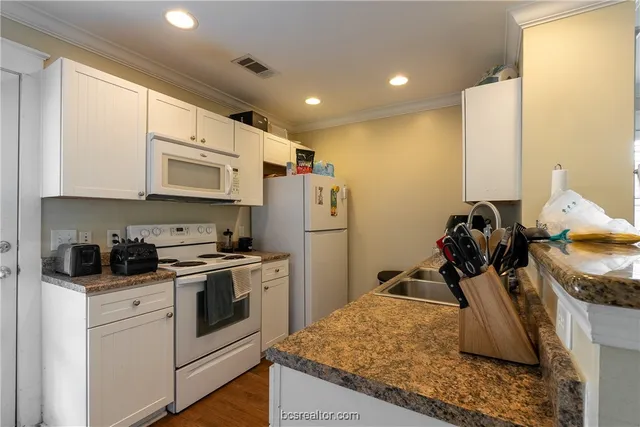 a kitchen with a sink appliances and cabinets