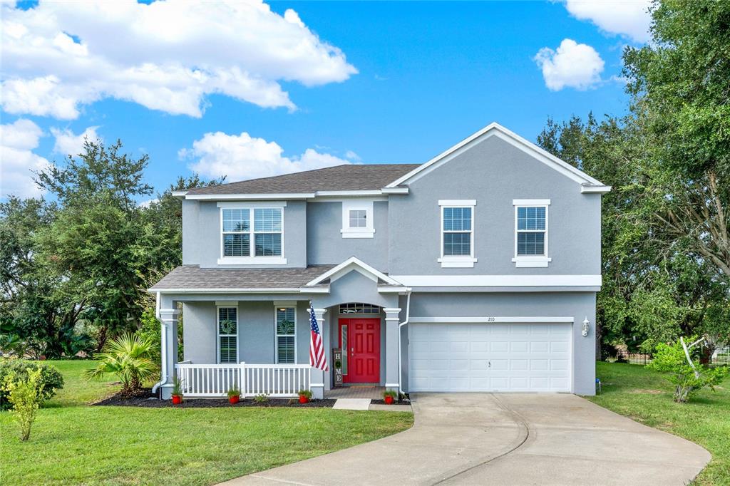 a front view of a house with a yard and trees