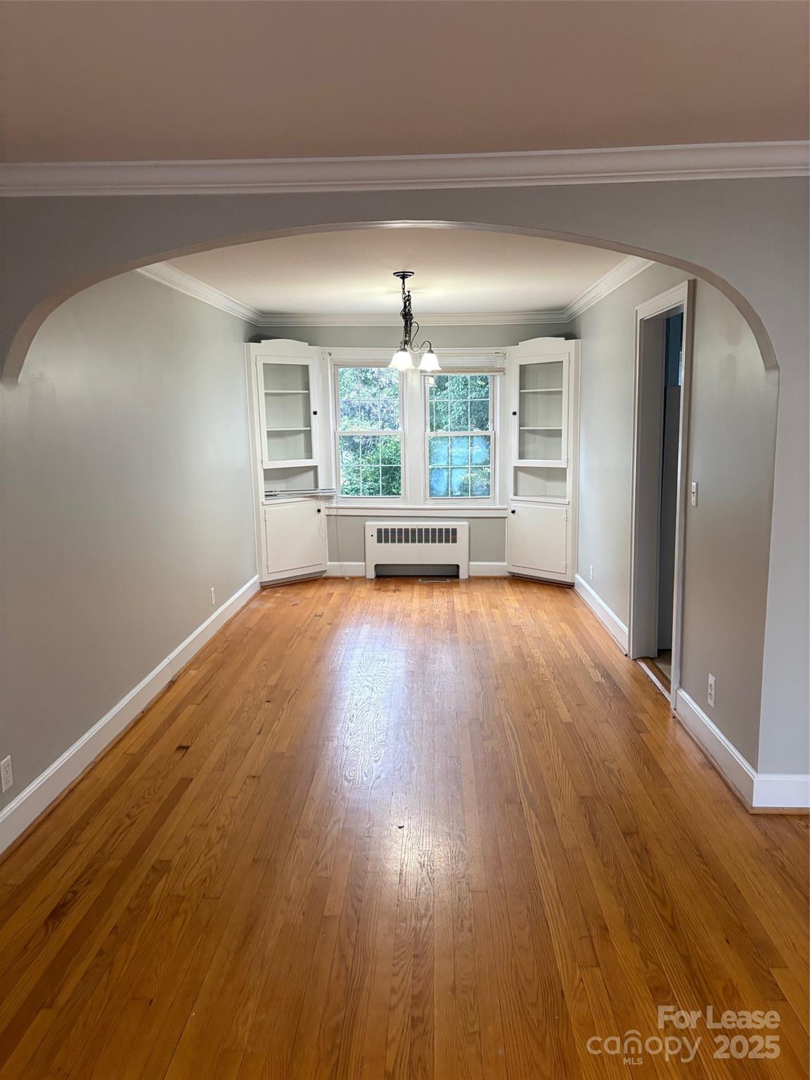 808 West Franklin Street Monroe, NC 28112 - Photo 2 of 9 wooden floor in an empty room with a window