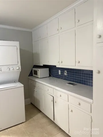a kitchen with white cabinets and sink