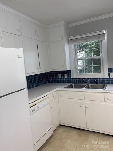 a kitchen with a refrigerator and white cabinets