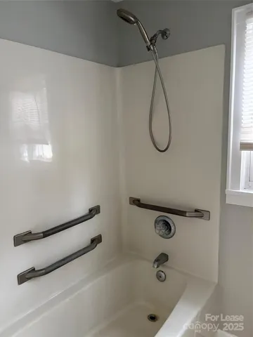 a bathroom with a bath tub with a shower