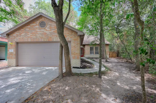 a view of a house with backyard and a tree