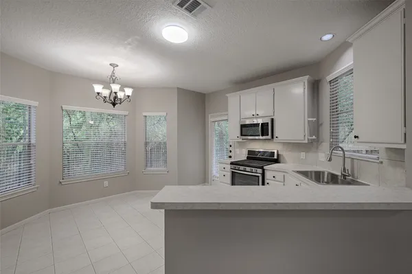a kitchen with stainless steel appliances granite countertop a sink stove and microwave