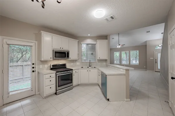 a kitchen with white cabinets and appliances