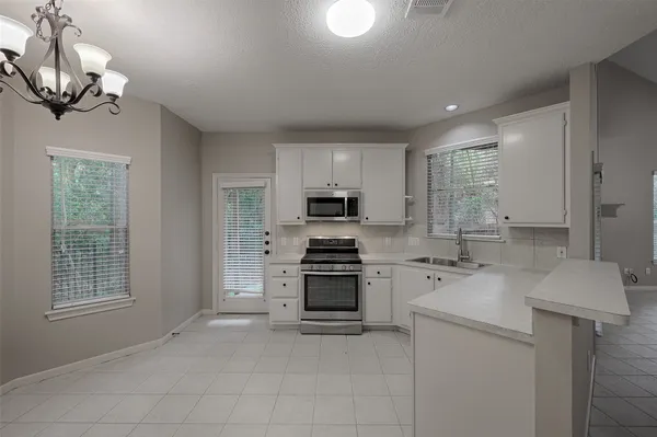 a kitchen with stainless steel appliances granite countertop a stove sink and cabinets