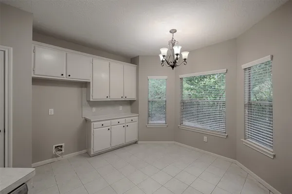 an empty room with chandelier and windows