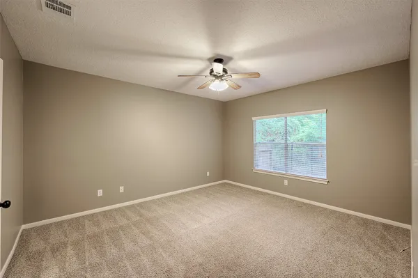 an empty room with a window and a fan