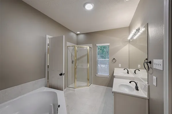 a bathroom with a sink a tub and a mirror