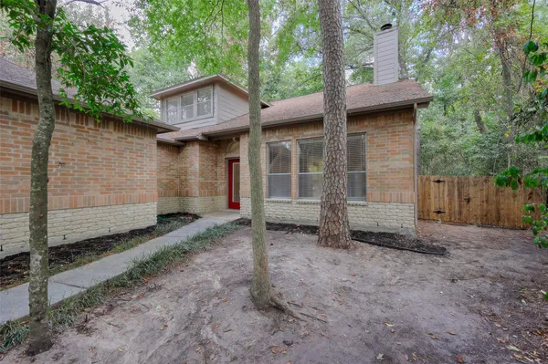 a view of a house with a yard and large tree