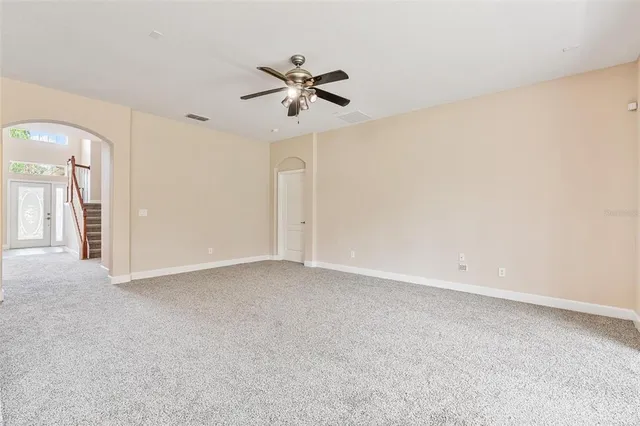 an empty room with windows and fan