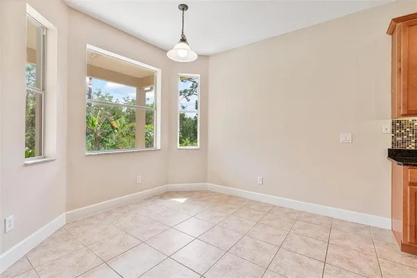 an empty room with windows and ceiling fan