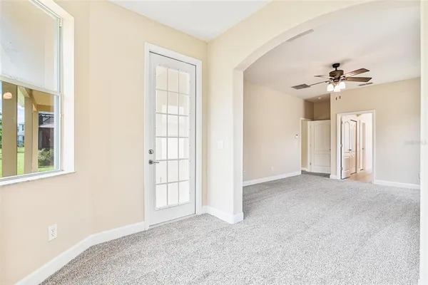 an empty room with a window and a fan