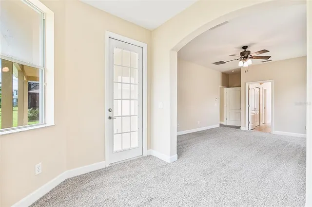 an empty room with a window and a fan