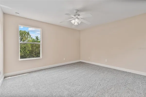 a view of a hallway with closet and a window