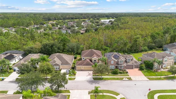 an aerial view of residential houses with outdoor space and swimming pool