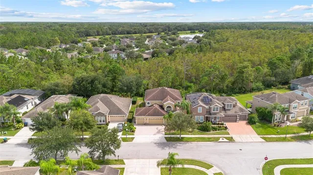 an aerial view of residential houses with outdoor space and swimming pool