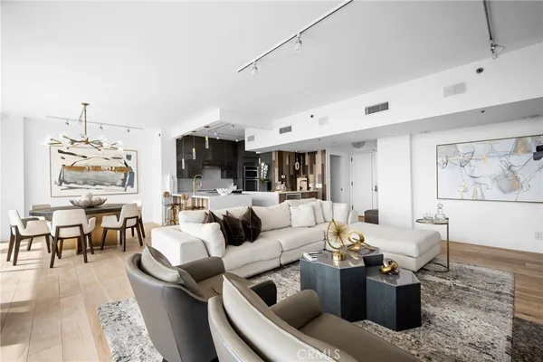 a living room with furniture and a view of kitchen