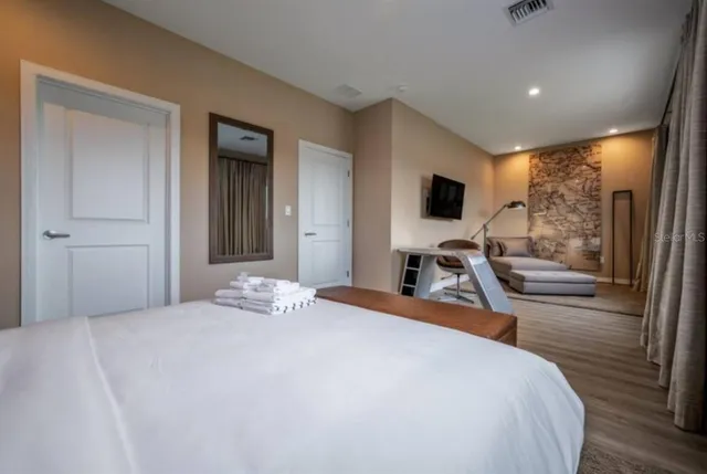 a bedroom with a bed and a flat screen tv