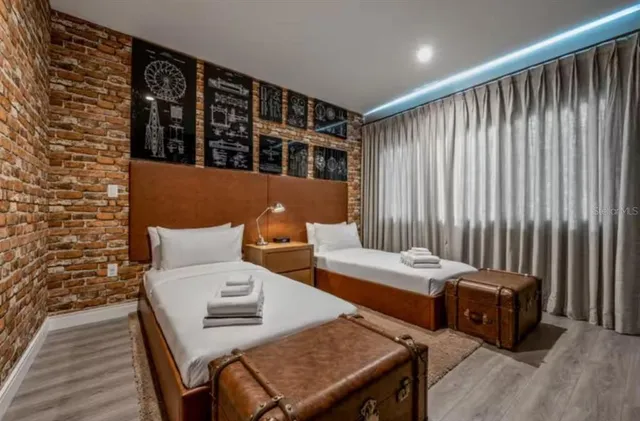 a bedroom with two beds and a wooden floor