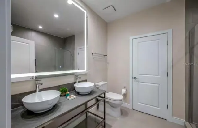 a bathroom with a granite countertop sink and a mirror