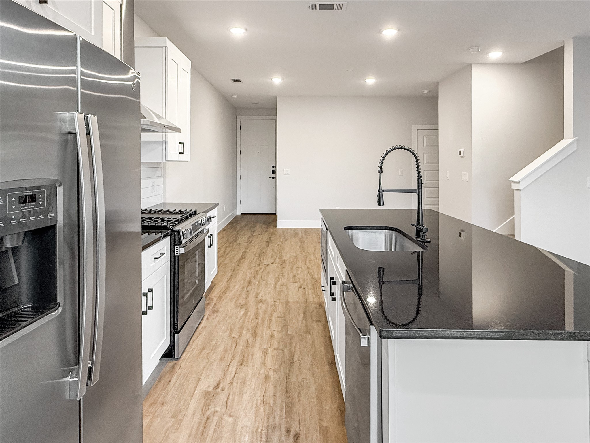 5611 Mobeetie Loop Bee Cave, TX 78738 - Photo 5 of 22 a kitchen with stainless steel appliances granite countertop a sink and a refrigerator