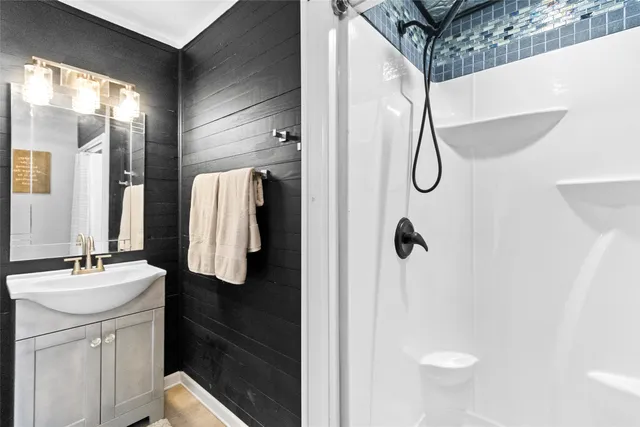 a bathroom with a sink vanity and shower