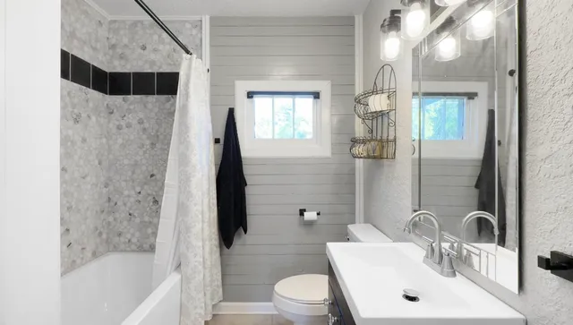 a bathroom with a sink a toilet and shower