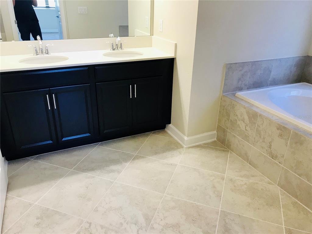 9020 Azalea Sands Lane Davenport, FL 33896 - Photo 4 of 16 a bathroom with a sink and a mirror