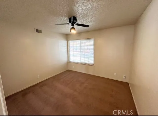 an empty room with a window and a ceiling fan