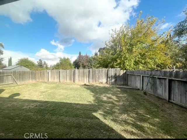 a view of yard with swimming pool and wooden fence